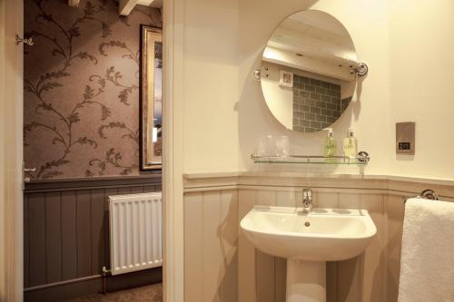 uma casa de banho com um lavatório e um espelho em Crofters Lodge em Barrow in Furness
