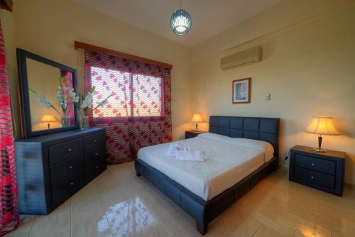 a bedroom with a bed and two lamps and a window at Villa Paradise in Paphos