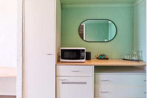 a room with a counter with a microwave and a mirror at Balmoral On York in Launceston