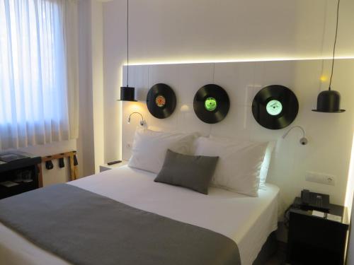 a bedroom with a bed with two records on the wall at Evenia Rocafort in Barcelona