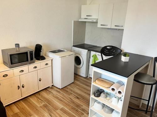 une cuisine avec un lave-linge et un micro-ondes dans l'établissement Joli studio cabine 28m2 à 300m de la mer, à Canet