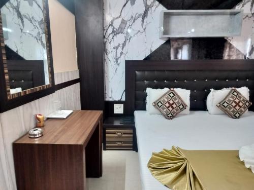 a bedroom with a large bed and a desk at Hotel Nagaon Point in Nowgong