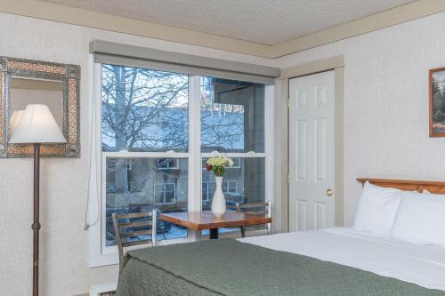 a bedroom with a bed and a window with a table at Mountainside Inn 417 by Alpine Lodging Telluride in Telluride