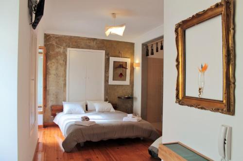 a bedroom with a large bed and a mirror at Casa d Sintra in Sintra