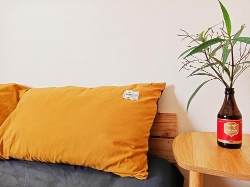 a bottle of beer sitting on a table next to a pillow at Ola's Home in Ho Chi Minh City