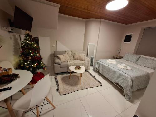 a living room with a christmas tree and a couch at Elise Corfu City Apartment in Ágios Rókkos