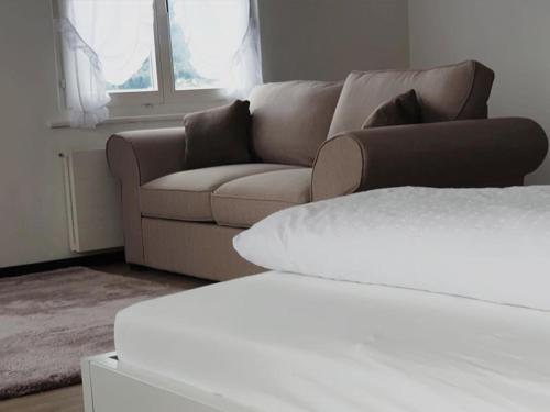 a living room with a brown couch and a window at Sternen Doppelzimmer in Benken