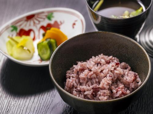 a bowl of pink rice and a plate of vegetables at Hanare no yado Kamigakure in Takachiho