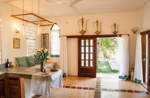 a living room with a table and a door at Mawimbi Cottage in Ukunda