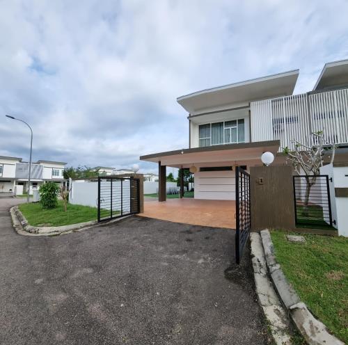 a house with a gate in front of a driveway at Stillwater Retreat in Desaru in Kota Tinggi
