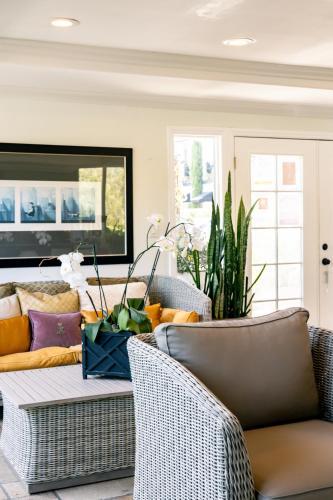 a living room with wicker chairs and a couch at Laguna Cove Hotel in Laguna Beach