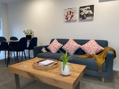 a living room with a blue couch and a table at A Hidden Gem near Hagley park in central city in Christchurch