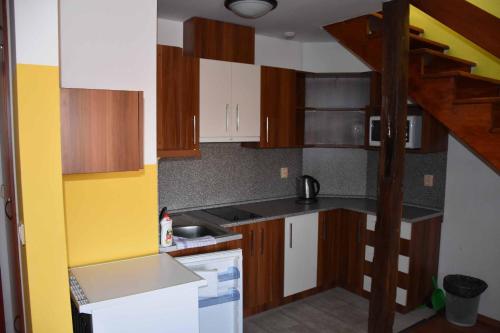 a small kitchen with wooden cabinets and a sink at Penzion U Holuba in Hradčovice