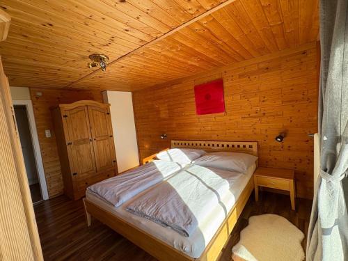 a bed in a room with a wooden ceiling at moderne Apartments am Attersee Dachsteinblick - ruhige Lage mit traumhaften Blick in Nussdorf am Attersee