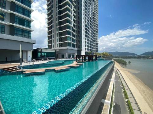 a large swimming pool with blue water in front of buildings at House Of 99 in Kuantan