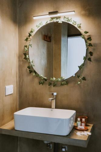 a bathroom with a white sink and a mirror at The Jini House in Ahangama