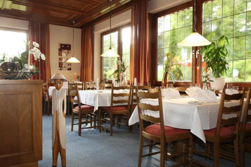 una sala da pranzo con tavoli, sedie e finestre di Hotel Sonne a Zell am Harmersbach