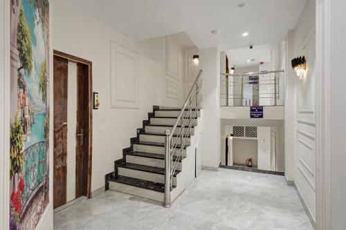 a staircase in a home with white walls and white floors at Hotel Saina International - Near Connaught Place & New Delhi Railway Station in New Delhi