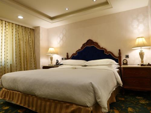 a bedroom with a large bed and two lamps at Royal Seasons Hotel Taipei ‧ Nanjing W. in Taipei