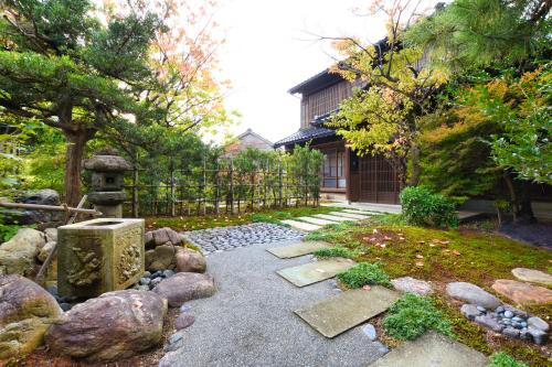 a garden with rocks and a fence and a house at 金沢之旅宿 あけぼの Kanazawa stay Akebono in Kanazawa