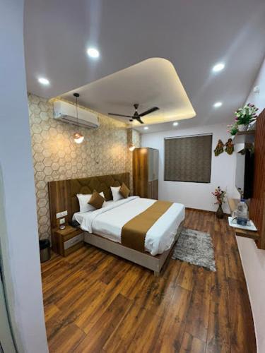 a bedroom with a large bed and wooden floors at Hotel Strawberry in Chandīgarh
