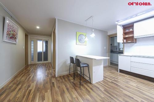 a kitchen with a desk and a table in a room at BOBOS Hotel in Jeju
