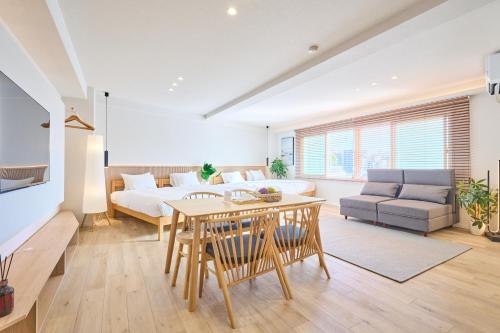 a living room with a table and a couch at STAY ARI Arakicho in Tokyo