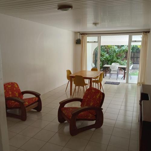 a dining room with a table and chairs and a patio at Town house beach 1 in Fare