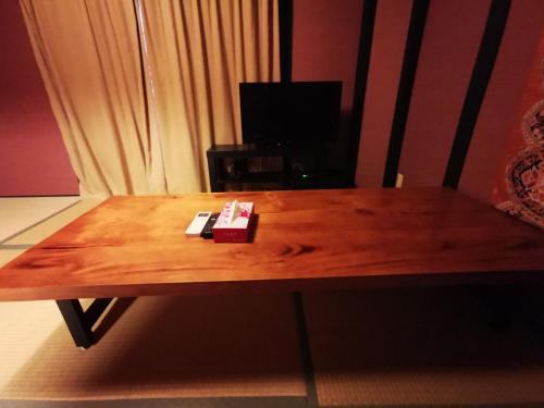 a wooden table with two cards on top of it at 足代サクラハウス一軒家 Sakura House Guest House WIFI付き Fuse Tsuruhashi 難波直通 最大8名 in Osaka