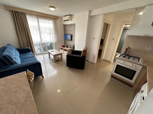 a living room with a blue couch and a kitchen at Kyrenia center, 2 bedroom, 1 living room, residential apartment in Kérynia