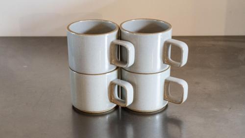 two white cups sitting on top of a table at ESPLANADE VILLAGE HOTEL b in Kamakura