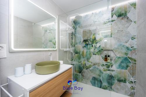 y baño con lavabo verde y ducha. en At The Plaza Central Beach Flat, en La Herradura