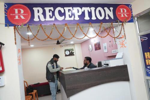 two men standing at a reception desk in a store at Hotel Raj Residency in Sītāmarhi