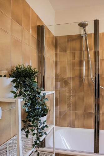 a bathroom with a shower and a tub with a plant at THE CORE - 4 min Walk to Bernina Express in Tirano