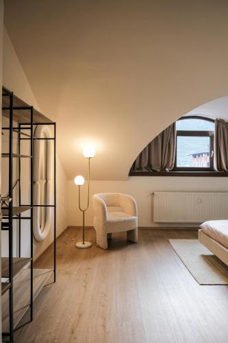 a bedroom with a bed and a chair and a window at THE CORE - 4 min Walk to Bernina Express in Tirano