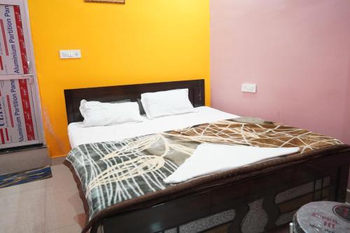 a bedroom with two beds with a yellow wall at Hotel Raj Residency in Sītāmarhi