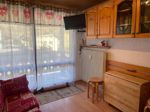 - un salon avec une table, une chaise et une fenêtre dans l'établissement T2 aux 2 Alpes - pied des pistes - centre station, à Les Deux Alpes