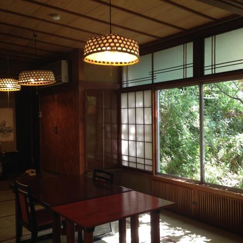a dining room with a table and windows at 中棚荘 in Komoro