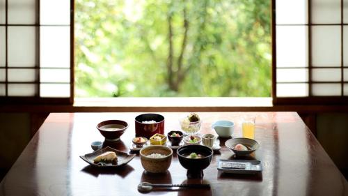 a table with bowls of food on it with a window at 中棚荘 in Komoro