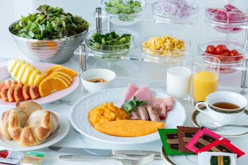 een tafel met borden met ontbijtproducten en drankjes bij UE Garden Resort in Chiba