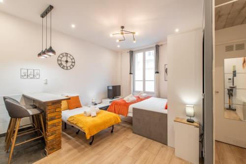- une chambre avec 2 lits, un bureau et une table dans l'établissement Cozy & Central Fully Equipped Studio 5 min walk to metro, Montparnasse neighbourhood, à Paris