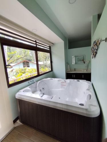 a large bath tub in a bathroom with a window at Bungalows Beachfront Hotel in Punta Uva