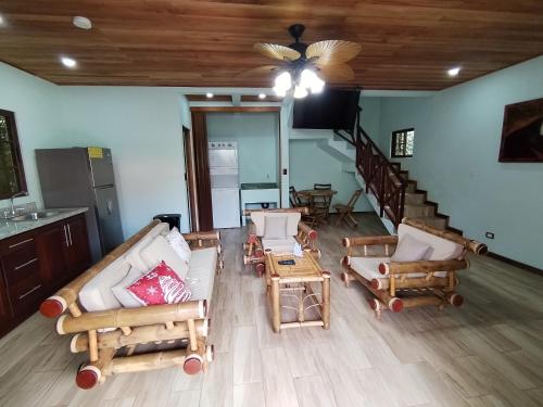 a living room with couches and chairs and a staircase at Bungalows Beachfront Hotel in Punta Uva