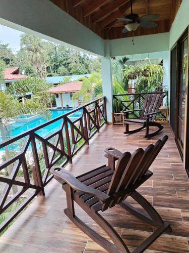 a deck with two chairs and a swimming pool at Bungalows Beachfront Hotel in Punta Uva