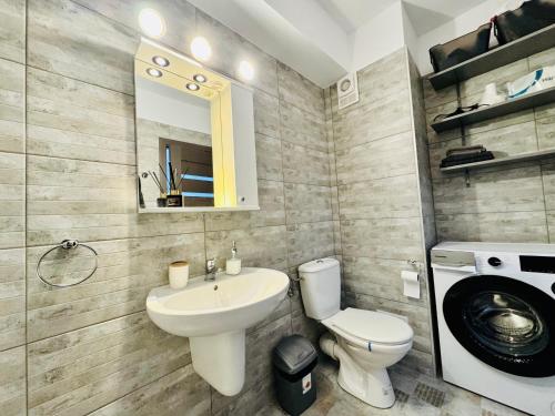 ein Badezimmer mit Waschbecken, Toilette und Spiegel in der Unterkunft Altheda Living Zircon A-37 in Suceava