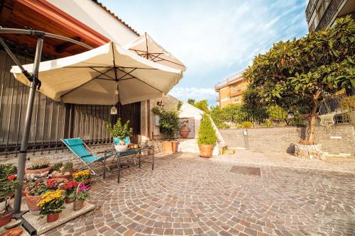 patio con ombrellone, tavolo e sedie di B&B La Casa Di Plinio a Pompei