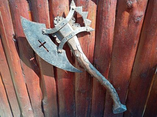 an old axe hanging on a wooden wall at Penzion Avalon in Valtice