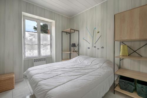 a bedroom with a white bed and a window at Plage à 200m, maison mitoyenne de plain-pied, 4 pers in La Bernerie-en-Retz