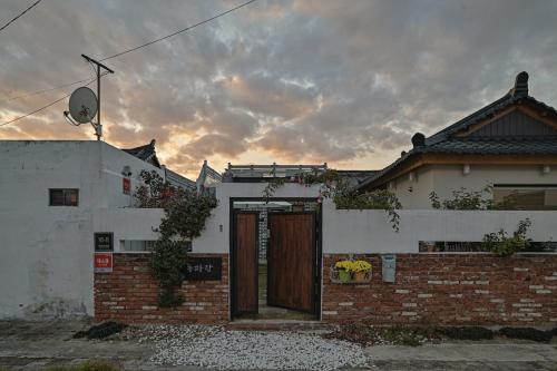 a brick house with a wooden door in a yard at Dongparang hanok stay in Gyeongju