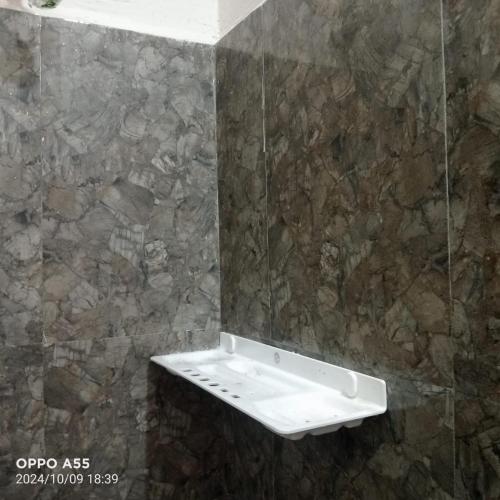 a bathroom with a mirror on a stone wall at Serenity Space in Dānishpet